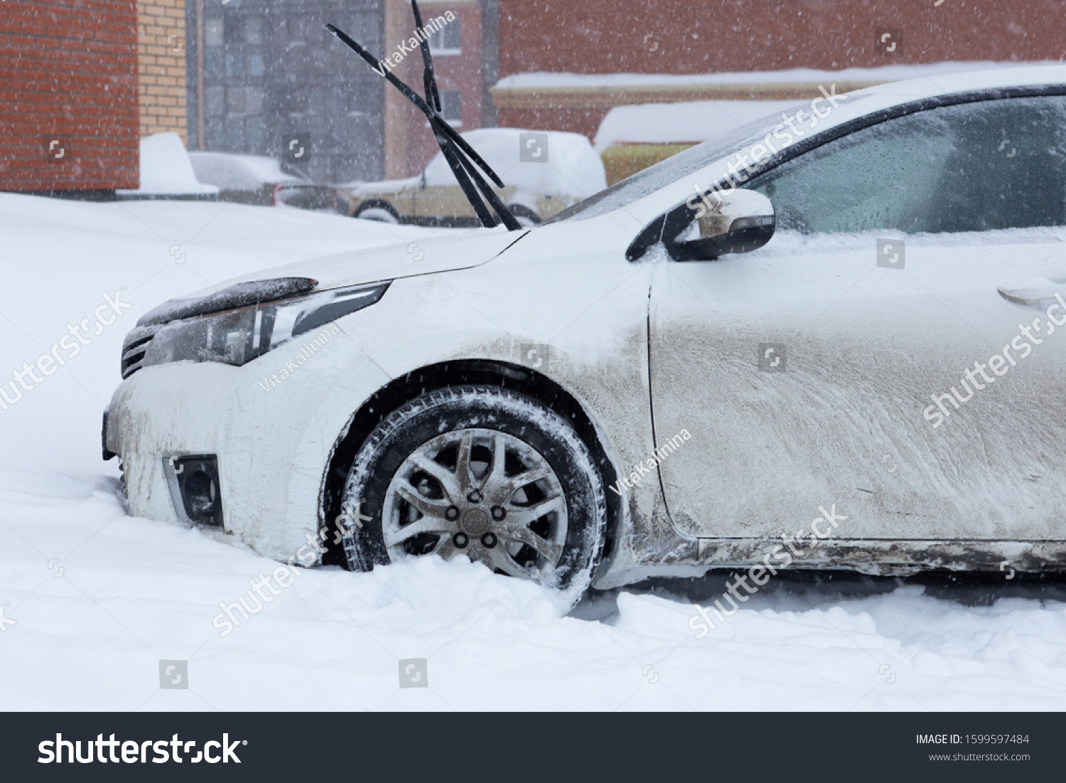 Novosibirsk, Novosibirskaya oblast/ russian federation - 12/15/2019: The front of a white car covered in mud and snow on a snowy day. #1599597484