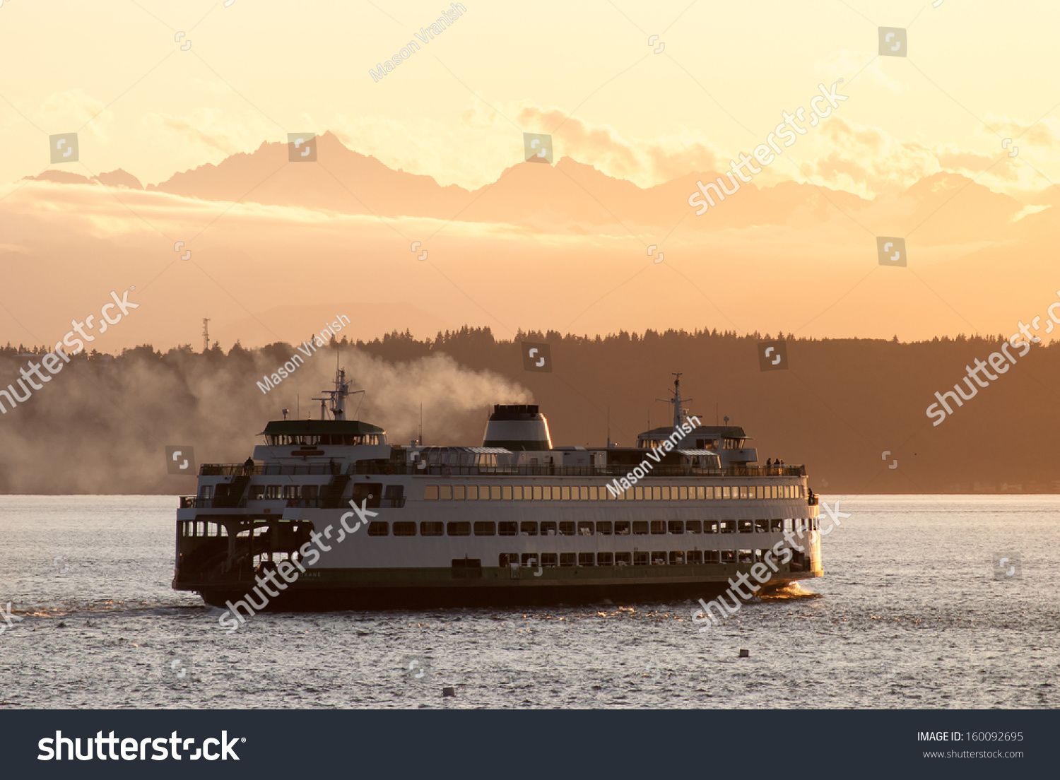 A Washington State ferry with the Olympic Mountains in the distance. #160092695