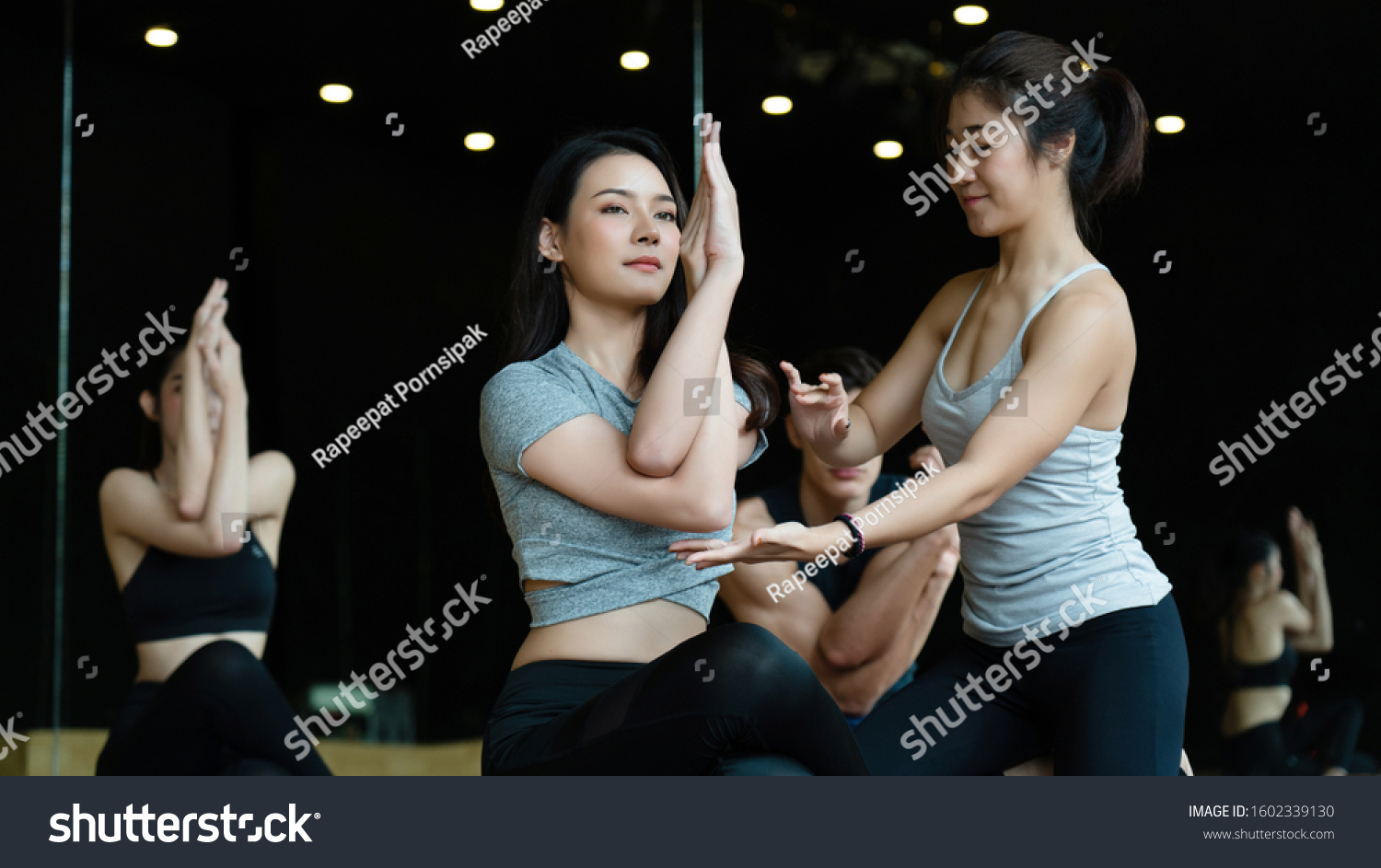Group of Asian women are doing yoga classes in the gym, wearing sportswear, and workout helps to have a healthy body, a good shape, relaxed muscles and a toned body. sports and healthcare concept #1602339130