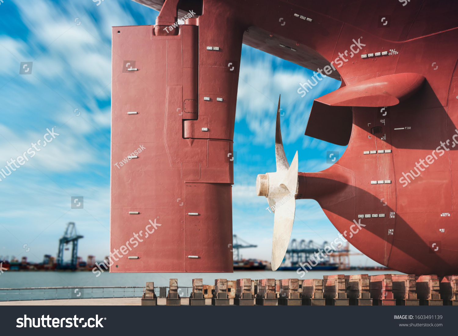 ship moored on sleeper At Stern ship Propeller with rudder under Reconstruction, Under the ship, Big ship under Repair on floating dry dock in shipyard #1603491139