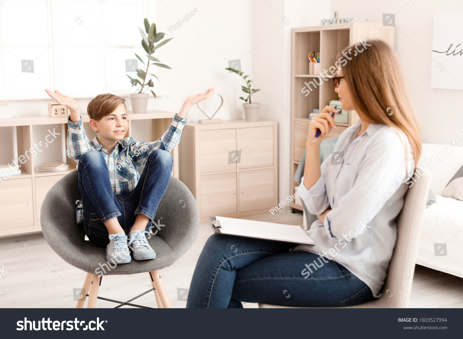 Female psychologist working with boy in office #1603527994