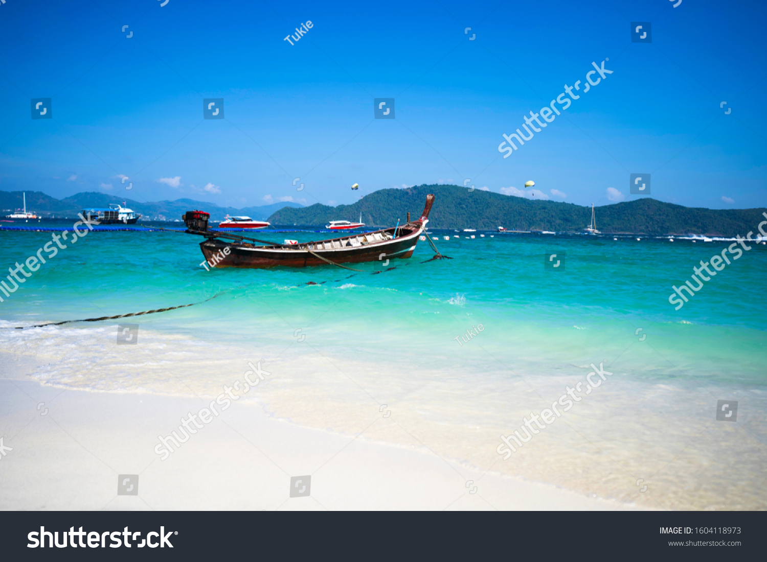 Fishing boat in the blue sea and white sand beach. #1604118973