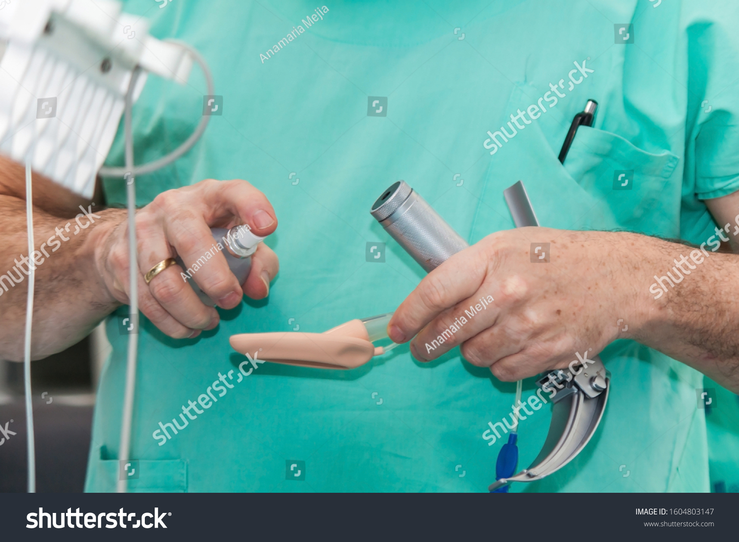 Anesthesiologist performing an endotracheal intubation to a female patient at the beginning of a surgery #1604803147