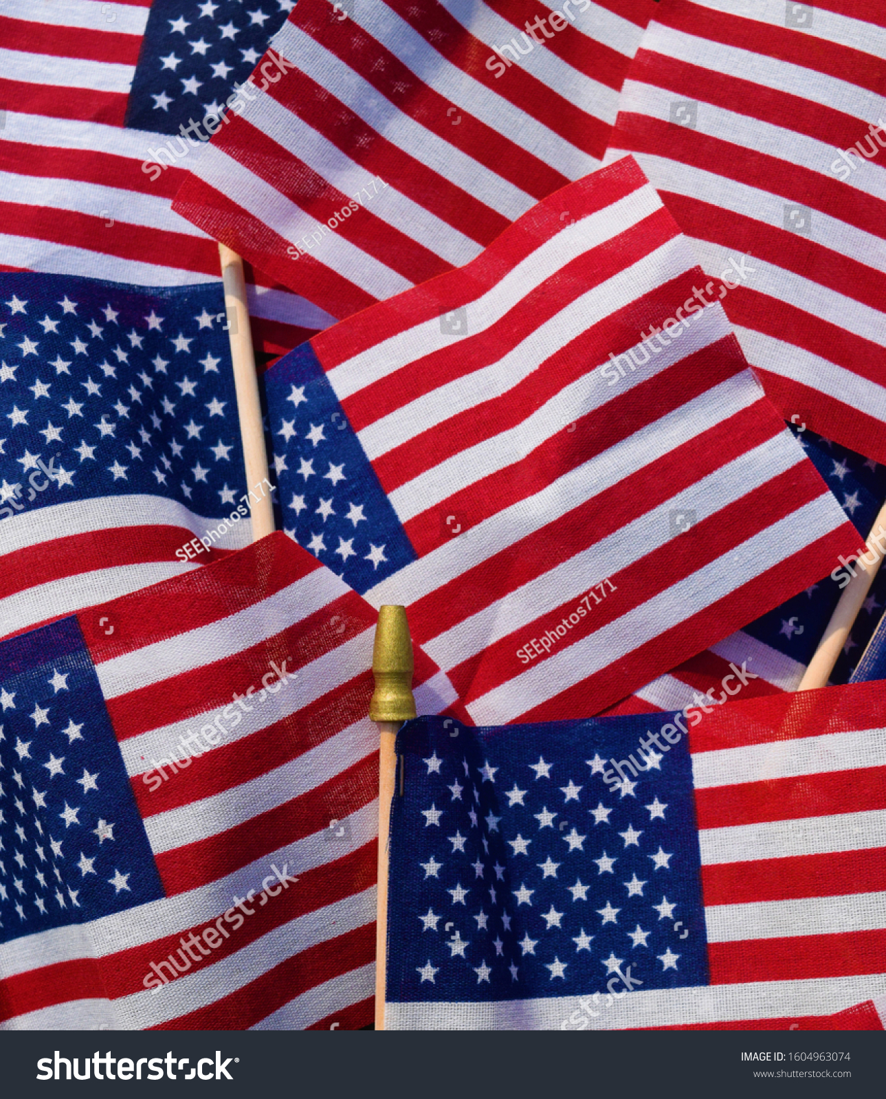 American stick flags in a pile in an array of patriotic colors #1604963074
