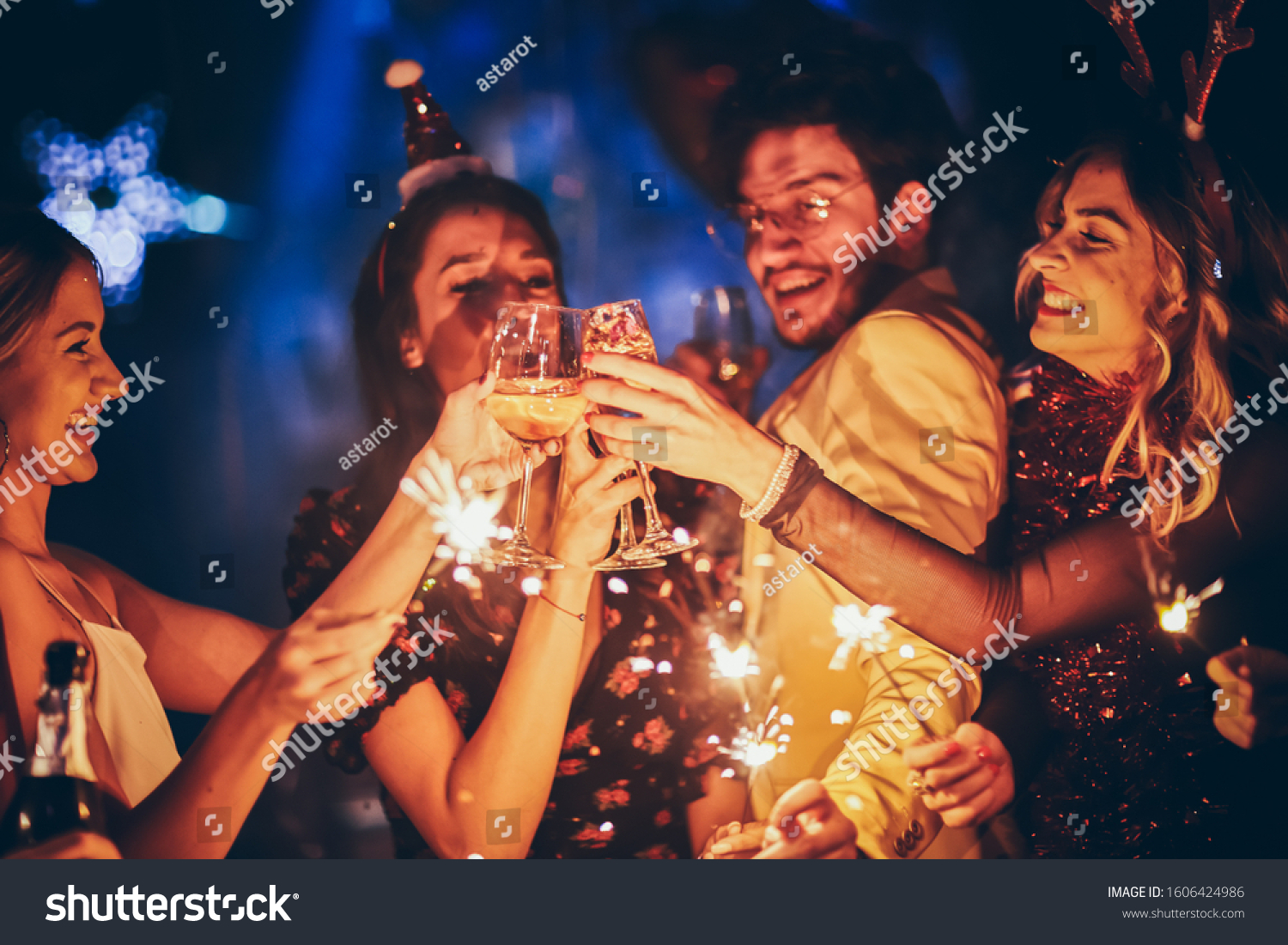 Group of friends having fun and holding sparklers at New Year's party #1606424986