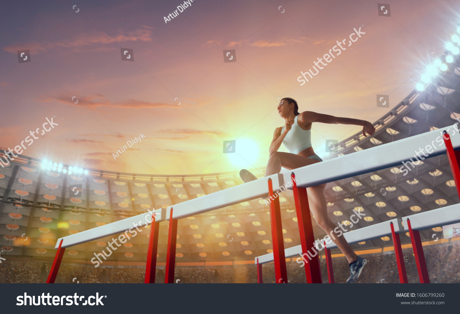 Athlete woman athlete jumps over the barrier at the running track in professional athletics stadium. #1606799260