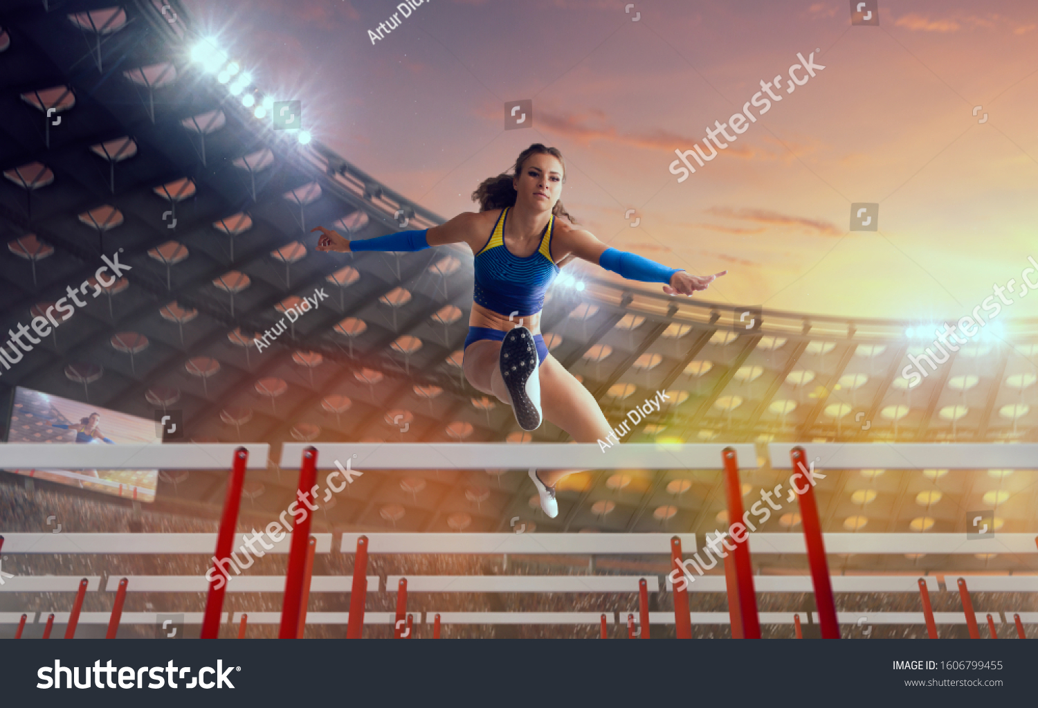 Athlete woman athlete jumps over the barrier at the running track in professional athletics stadium. #1606799455