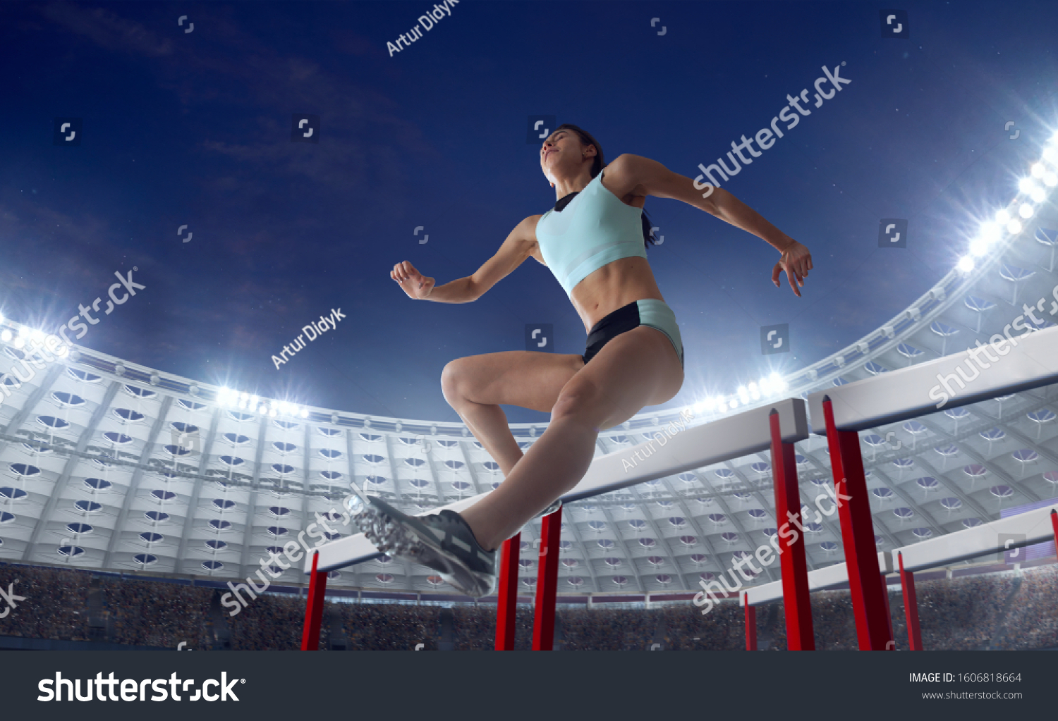 Athlete woman athlete jumps over the barrier at the running track in professional athletics stadium. #1606818664