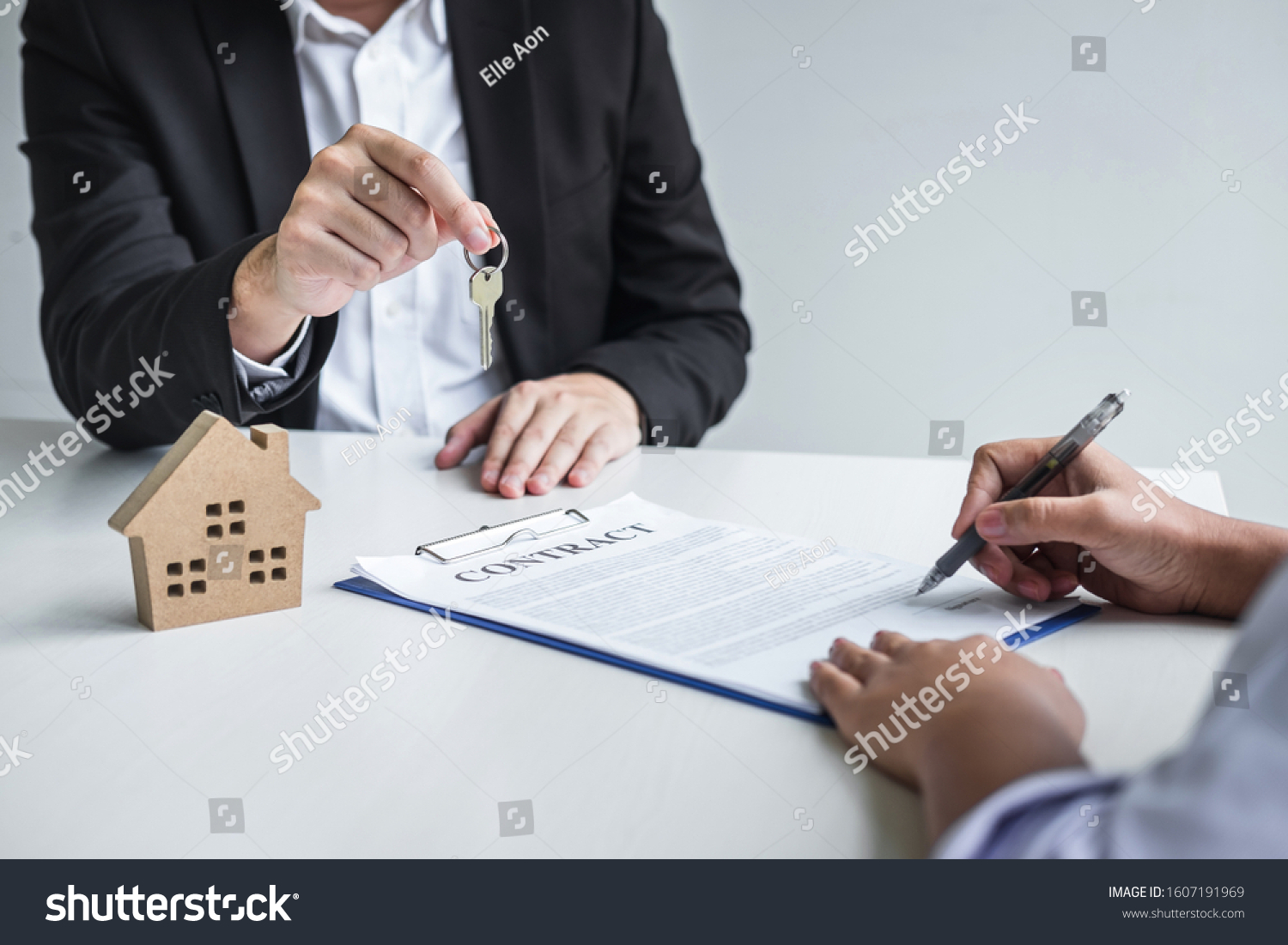Estate agent giving house keys to client after signing agreement contract real estate with approved mortgage application form, concerning mortgage loan offer for and house insurance. #1607191969