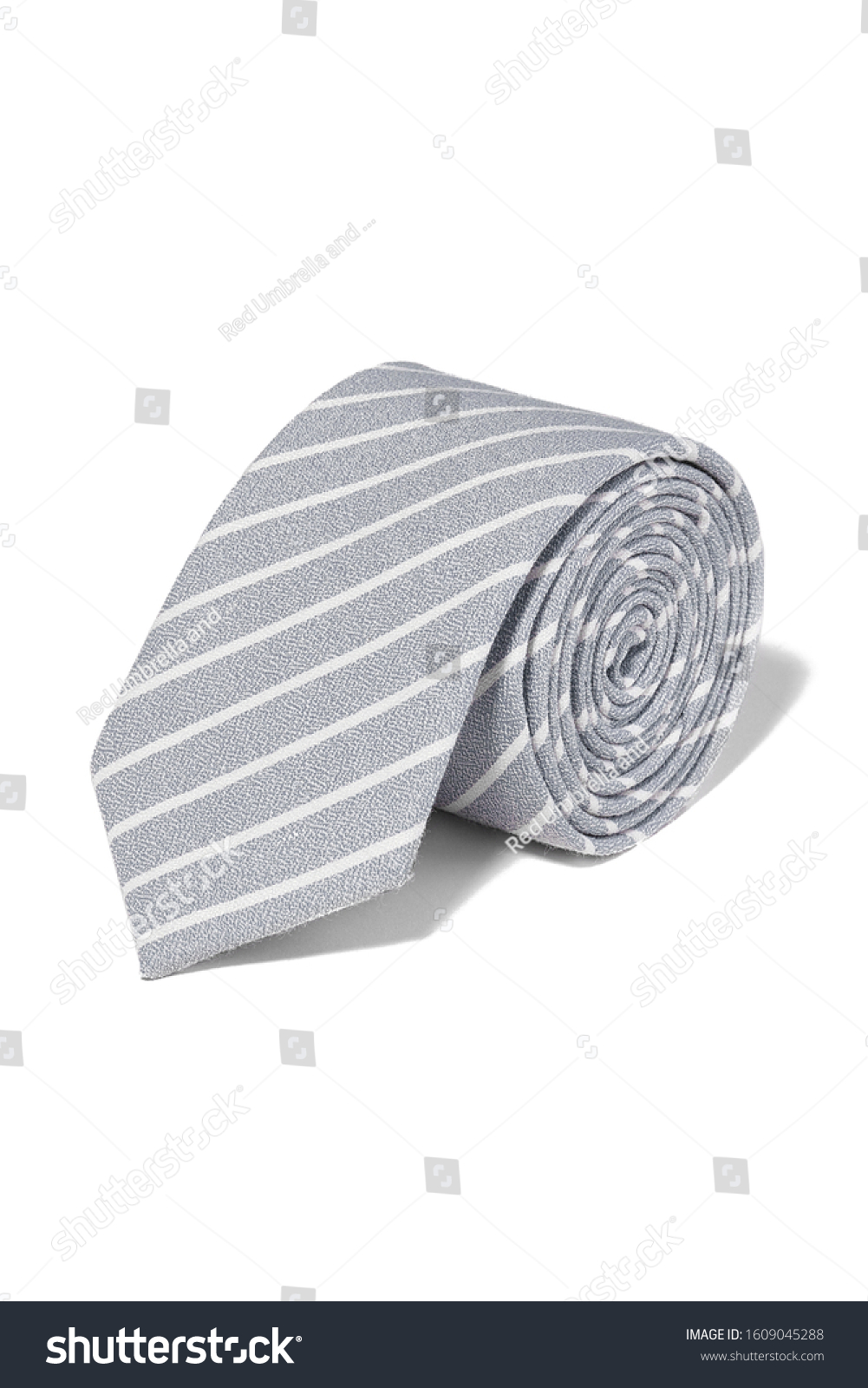 Subject shot of a rolled-up classic cotton tie made of silver gray textured fabric with white diagonal stripes. The necktie is isolated on the white background. #1609045288
