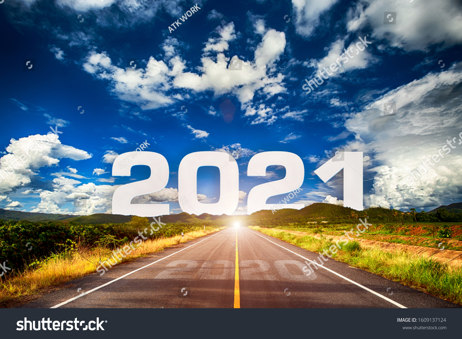 The word 2021 behind the mountain of empty asphalt road at golden sunset and beautiful blue sky. Concept for vision year 2021.  #1609137124