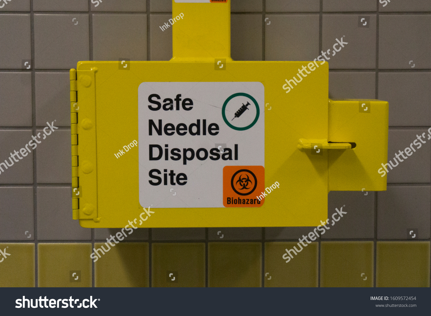 Safe medical needle disposal container on a toilet wall #1609572454