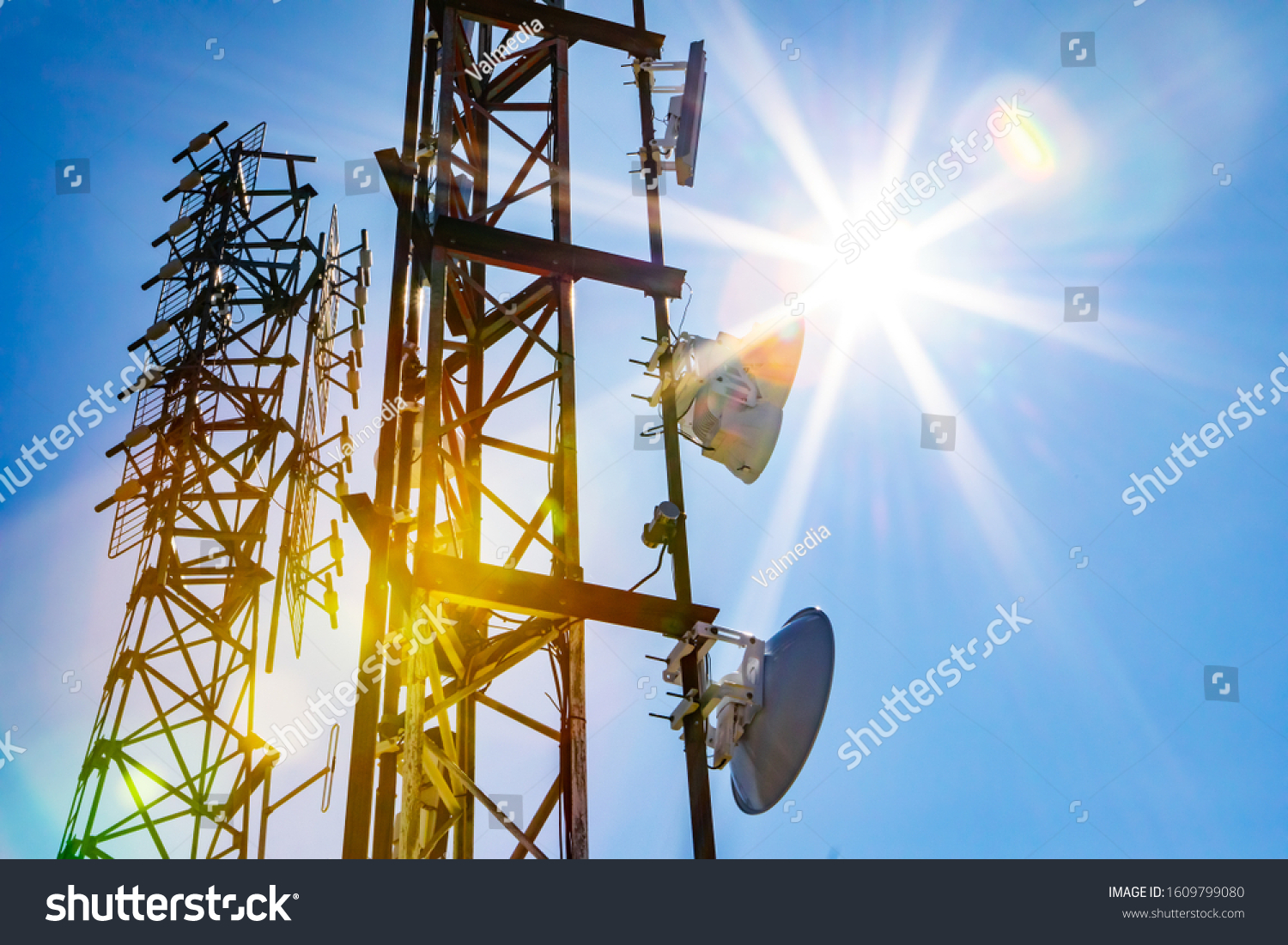 Electromagnetic radiation under the hot summer sun, colorful radioactive pollution concept with two cellular network towers and copy space to right #1609799080
