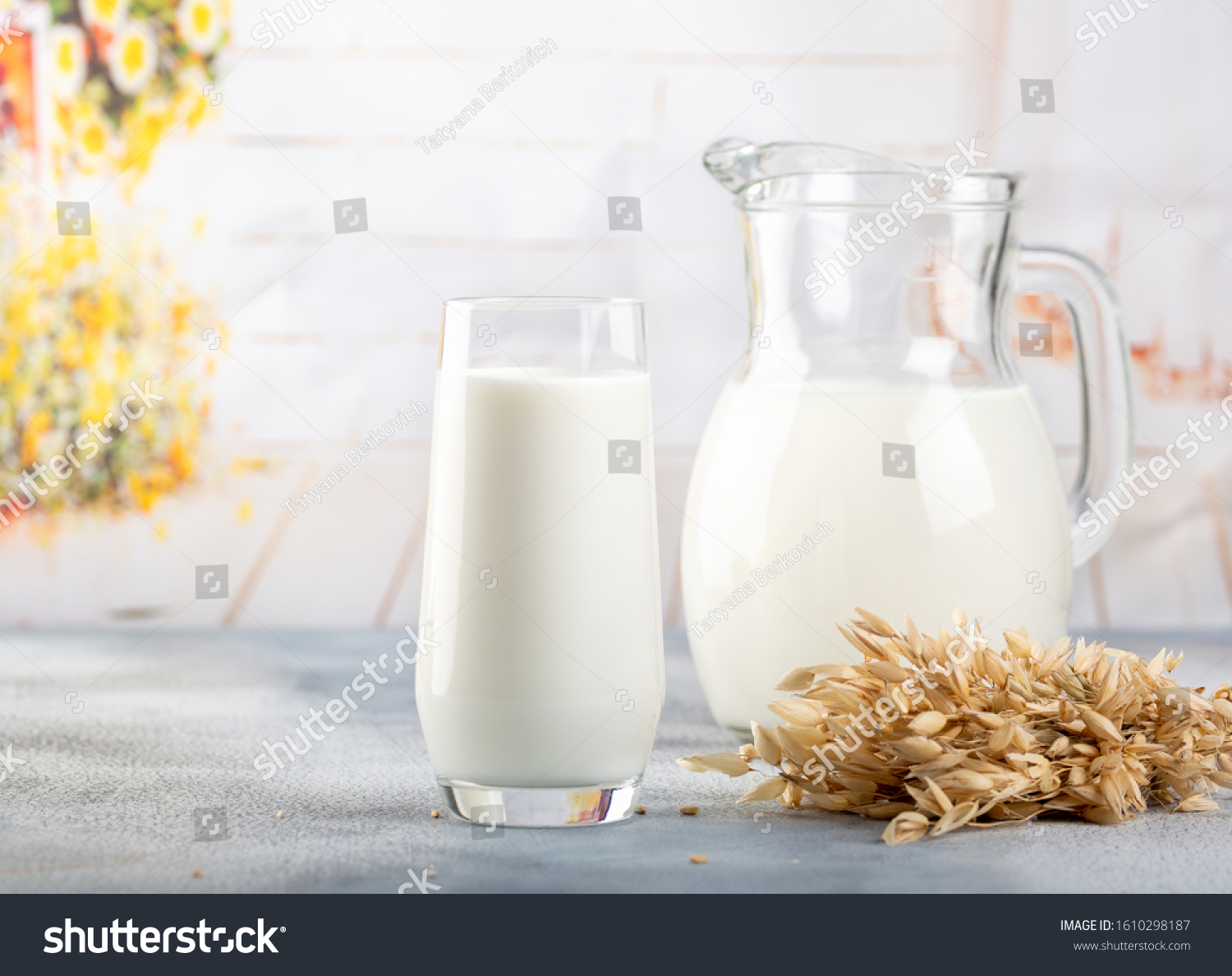 Glass of vegan oat milk and Oat on a table, space for text. Light background #1610298187