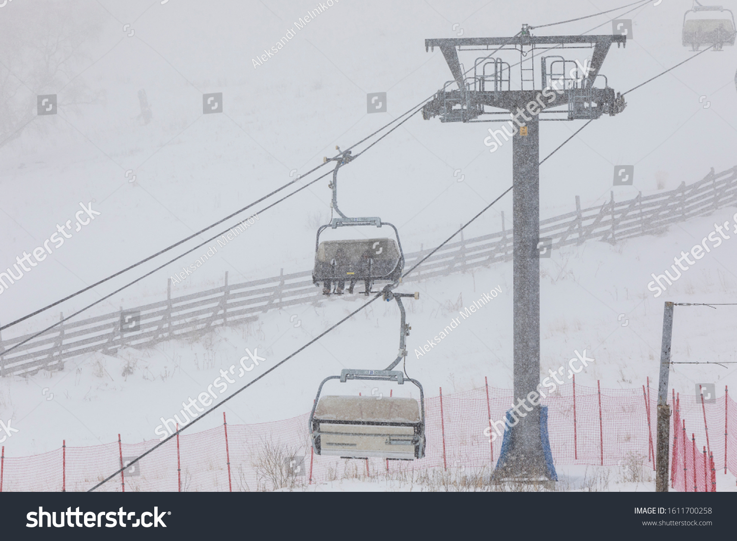 People climbing a cable car downhill in a snowfall #1611700258