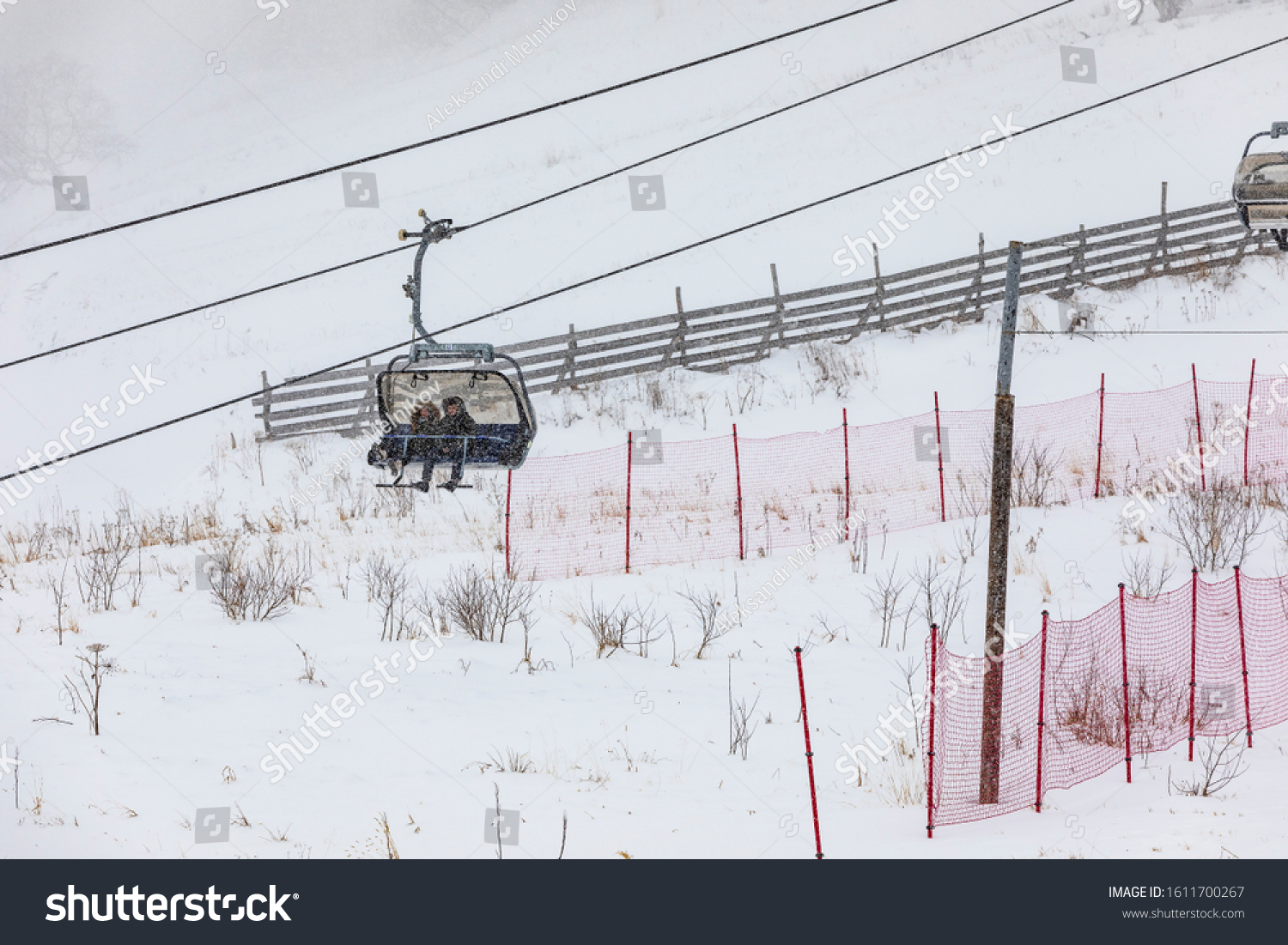 People climbing a cable car downhill in a snowfall #1611700267