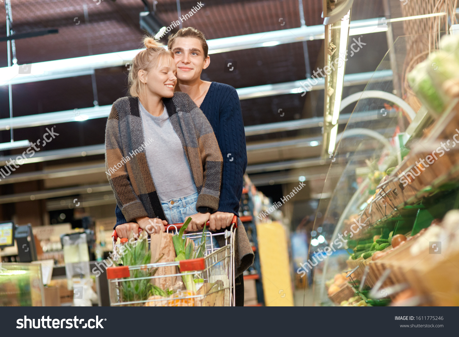 Young couple at the supermarket doing daily shopping walking with cart hugging romantic smiling cheerful just walk out shopping technology #1611775246