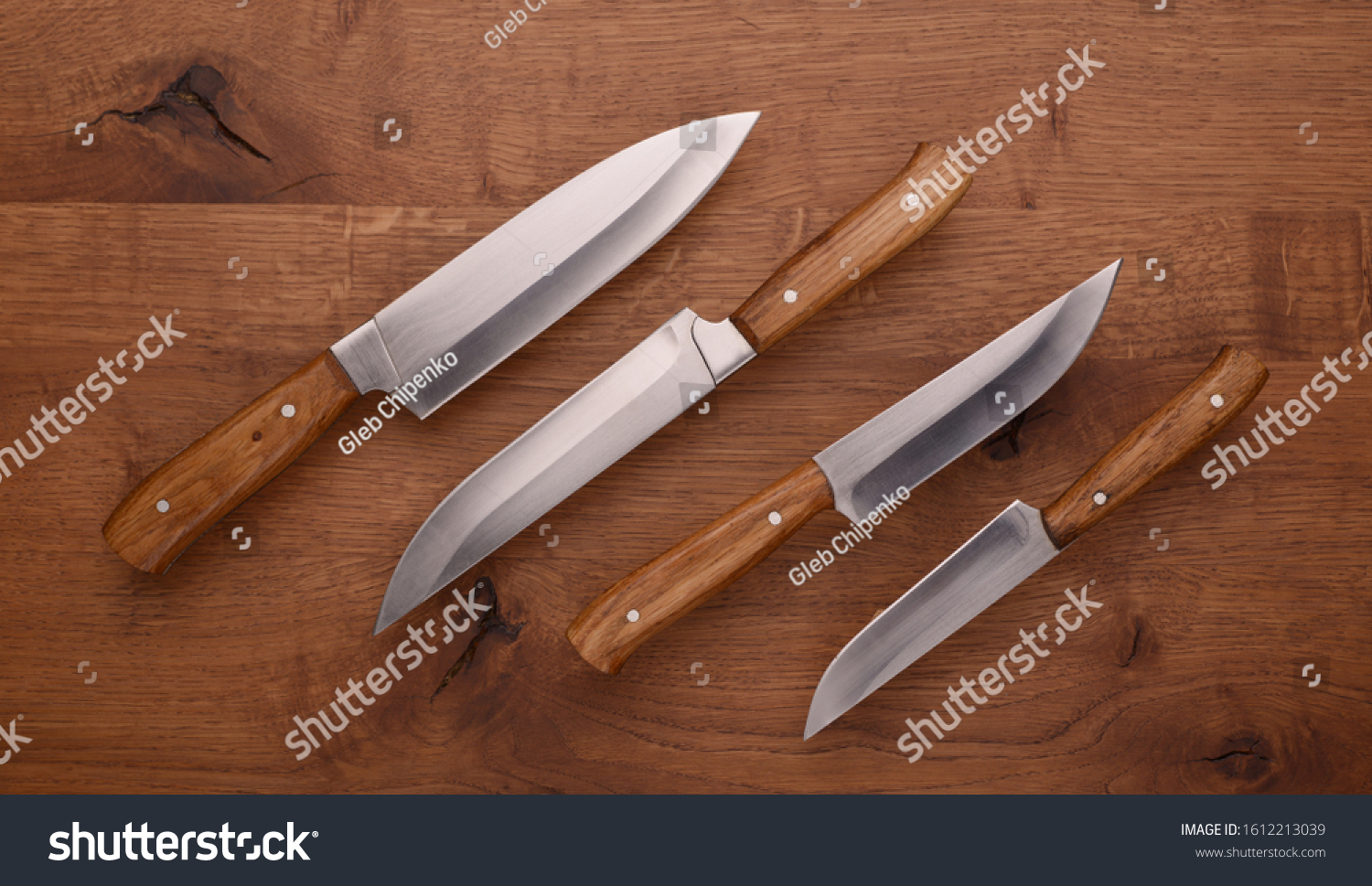 Set of knives on a wooden table. Kitchen knives with wooden handles. #1612213039