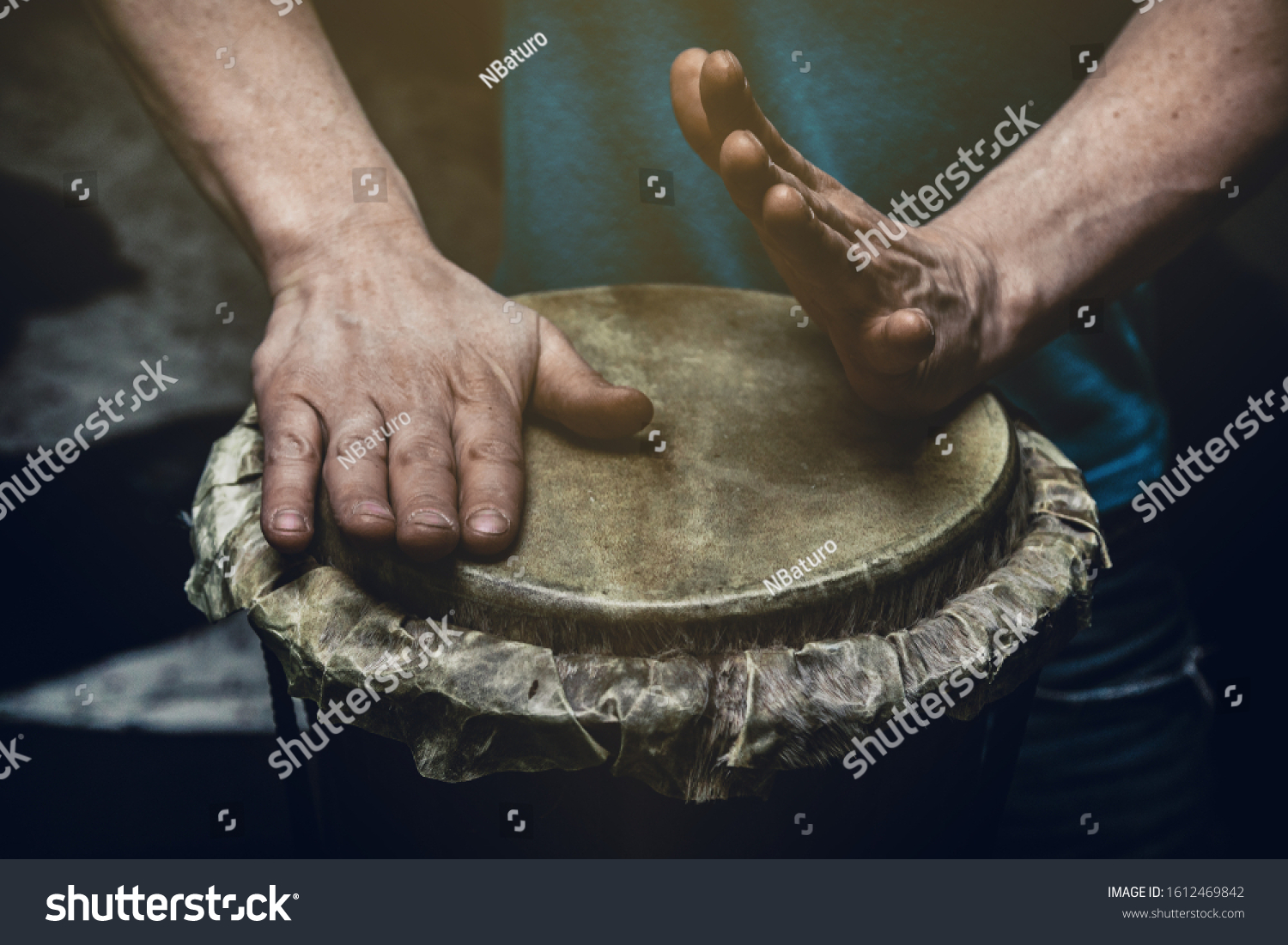 Ethnic percussion musical instrument jembe and male hands #1612469842