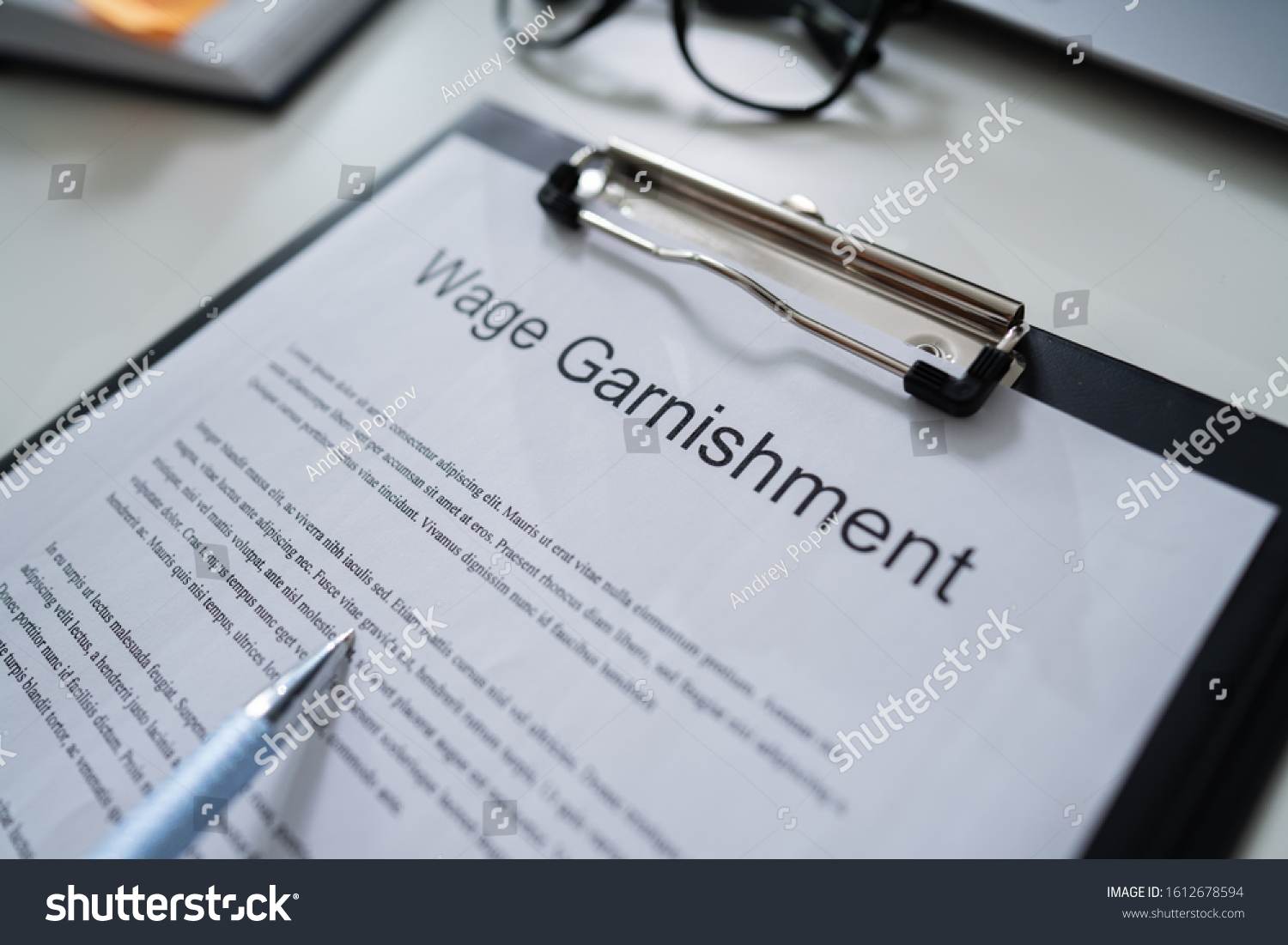 Person Reading  Wage Garnishment Documents At Desk #1612678594