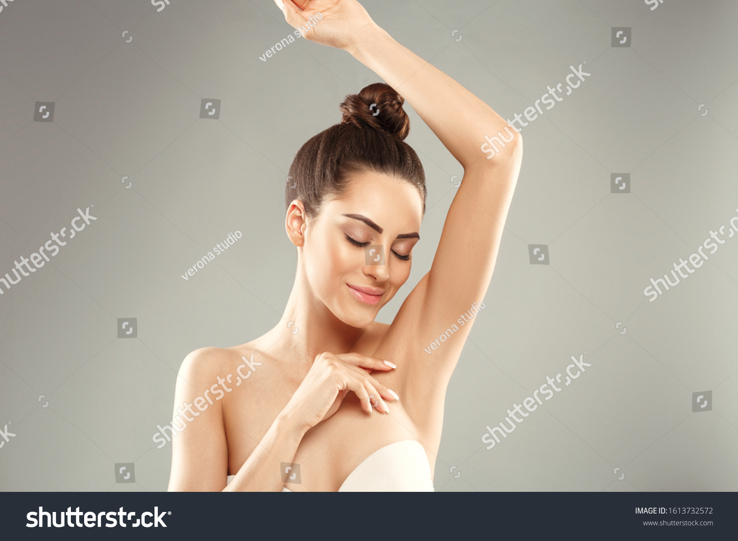 Armpit epilation, lacer hair removal. Young woman holding her arms up and showing clean underarms, depilation  smooth clear skin .Beauty portrait. #1613732572