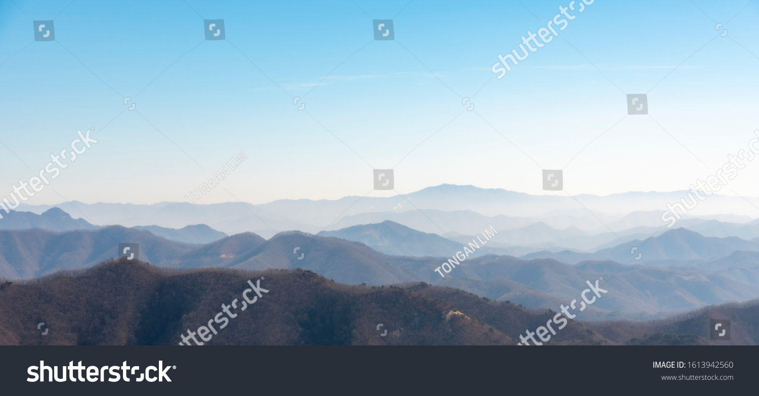 The mountains of Korea have become impressive landscapes due to the blue sky and fog. #1613942560