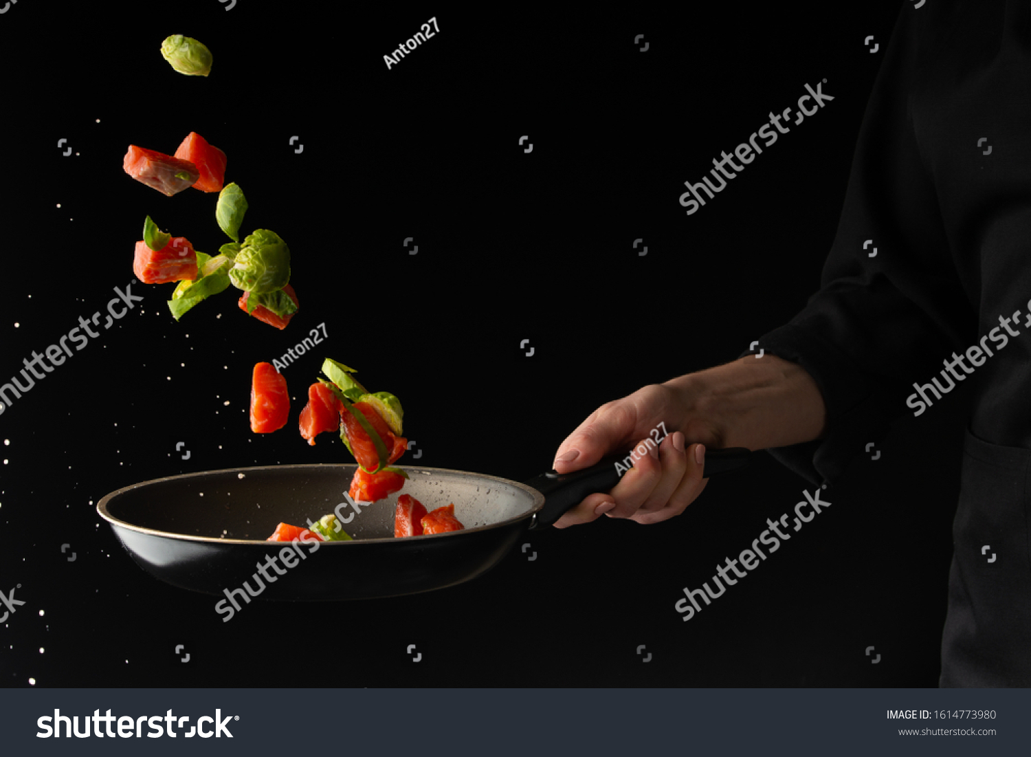 sea ​​or ocean food. Frying in a pan of salmon, with vegetables. Useful and tasty food. Culinary and gastronomy. Freezing in motion. On a black background, horizontal photo. #1614773980