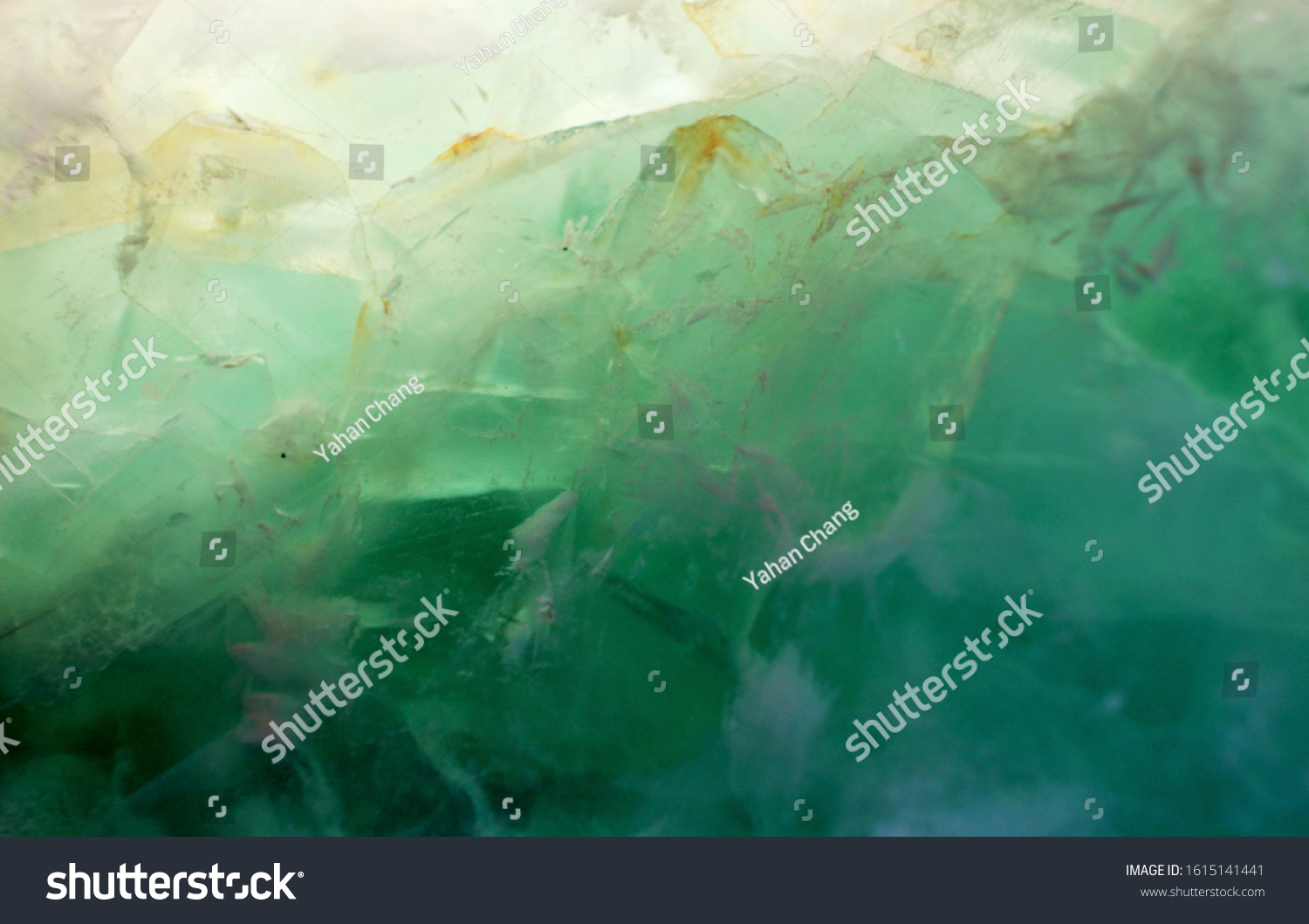 A close up picture of green jade though the light, the pattern of the jade is like dreamy mountain made by ice. Can be used as background of natural, green topic. #1615141441
