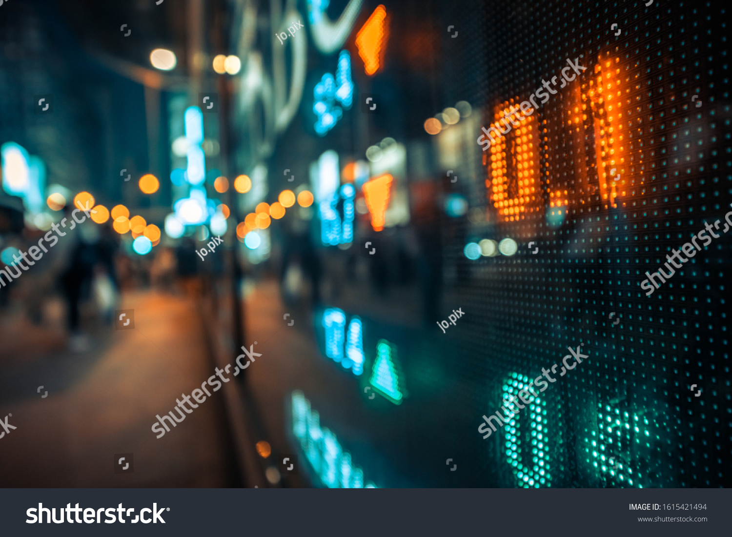Display stock market numbers and graph with city light reflections at the street. Small focus line, some noise. Blurry. #1615421494