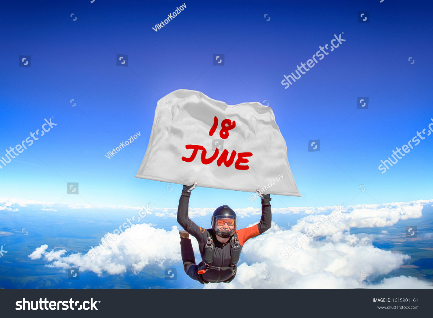 18 June. Parachutist flies a flag with date of June 18. Skydiver in black suit. Extreme as a way of life. 
 #1615901161