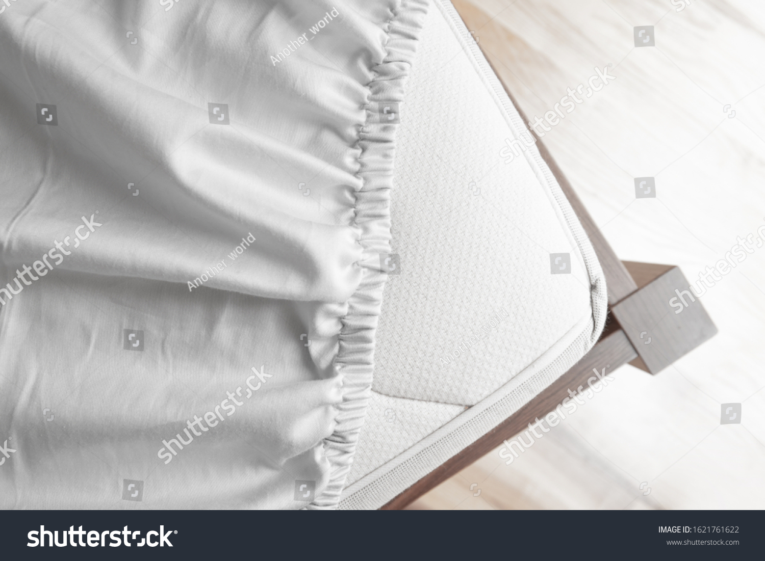 Bed corner with white fitted sheet. White sheet with elastic band. Bed cover. #1621761622