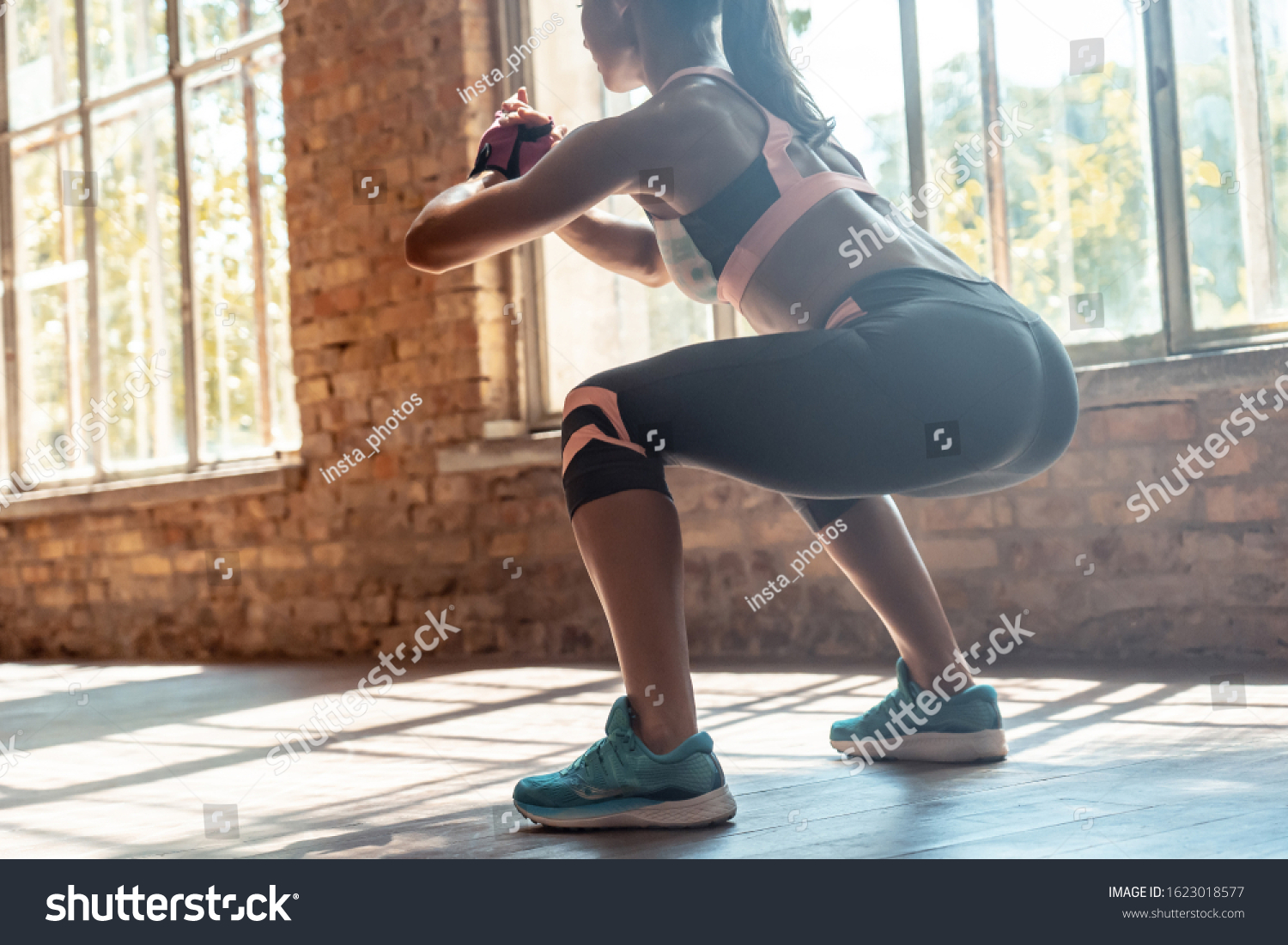 Young fit sporty active athlete woman wear sportswear crouching doing squats session fitness training legs buttocks muscles workout exercise in modern sunny gym space indoors, rear back close up view #1623018577