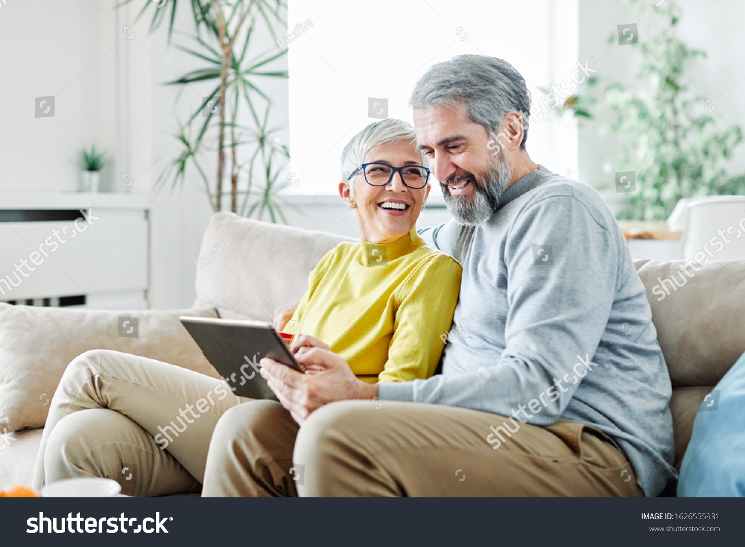 portrait of happy smiling senior couple using tablet at home #1626555931