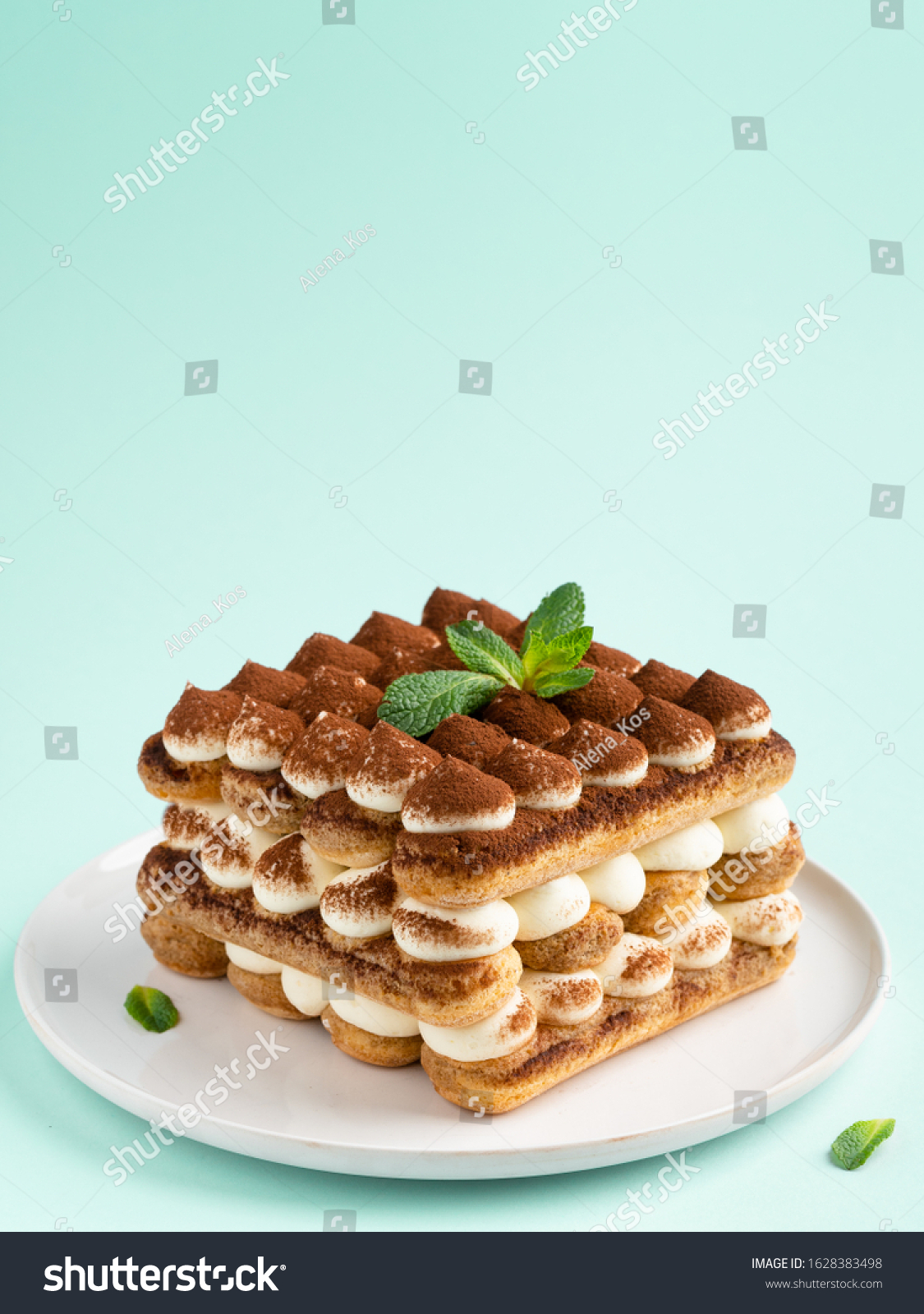 Tiramisu , italian layered dessert with mascarpone cream, decorated with mint and cocoa powder.  #1628383498
