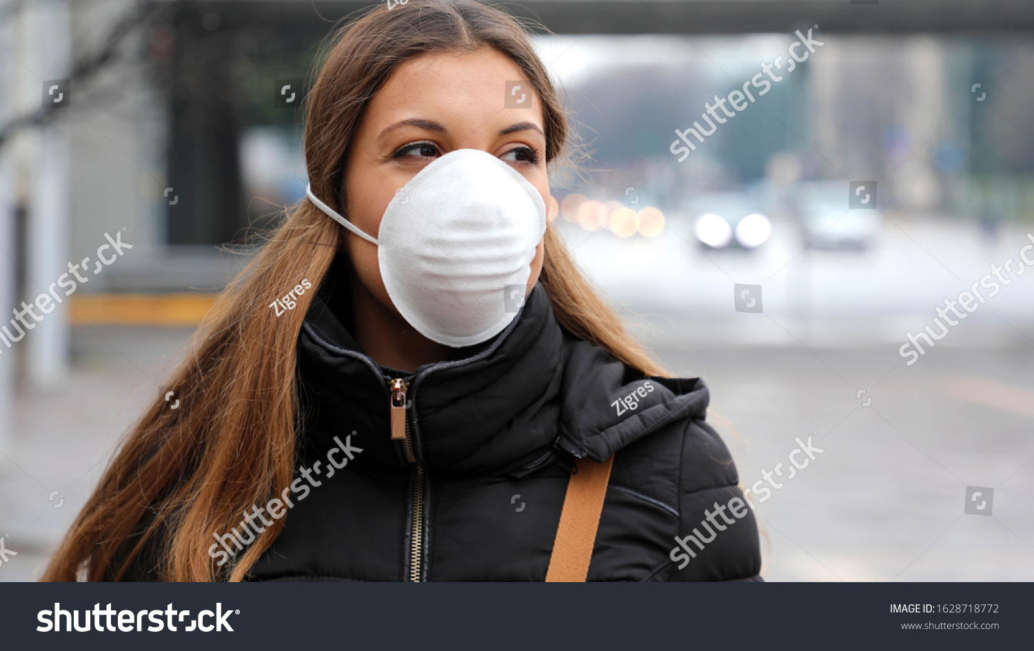 COVID-19 Pandemic Coronavirus Young Girl in city street wearing face mask protective for spreading of Coronavirus Disease 2019. Close up of young woman with protective mask on face against SARS-CoV-2. #1628718772