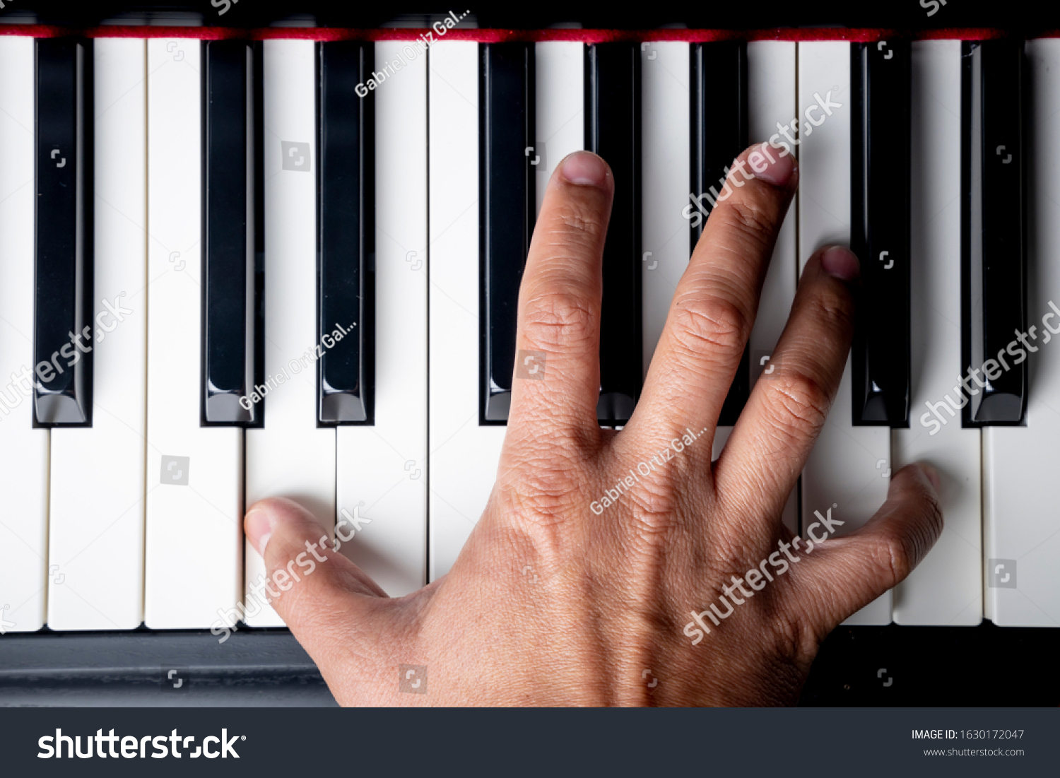 right hand playing a D octave chord on the piano #1630172047