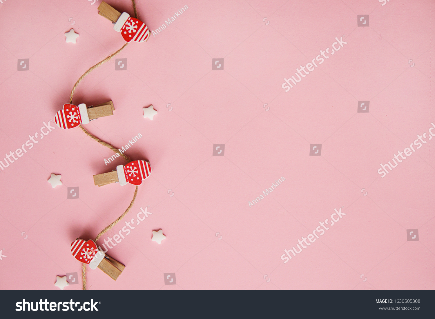 Christmas decorations decorative background. Decorative pins in the form of red gloves on a pink background. Top view, minimalism, flat lay. #1630505308