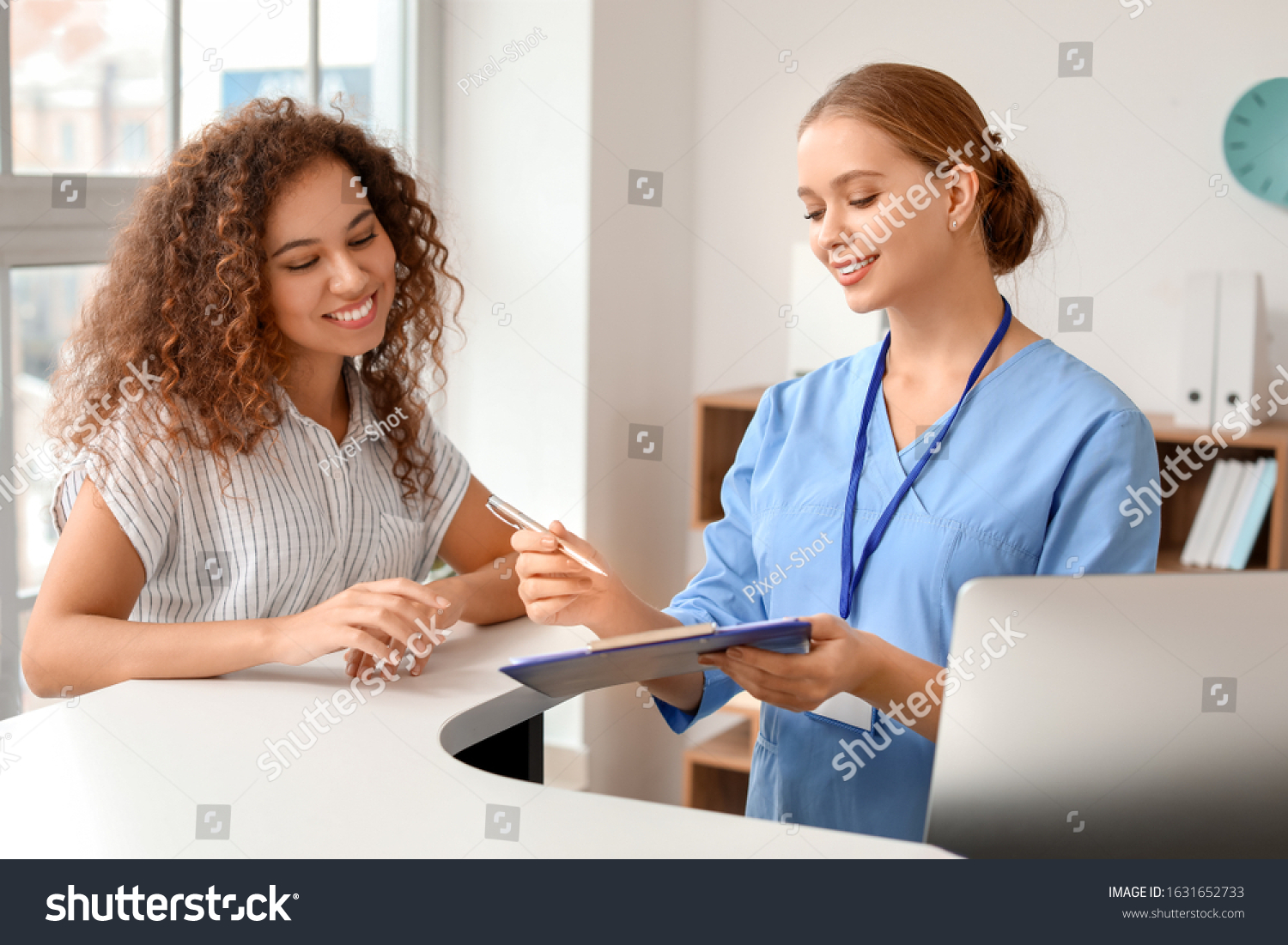 Young female receptionist working with patient in clinic #1631652733