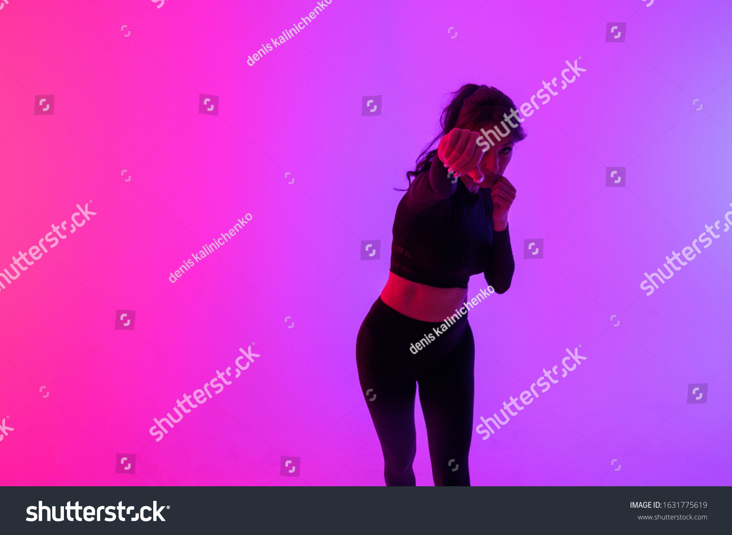 Beautiful, confident woman boxer athletic wearing gloves strikes punching on Colorful background, vibrant colors #1631775619
