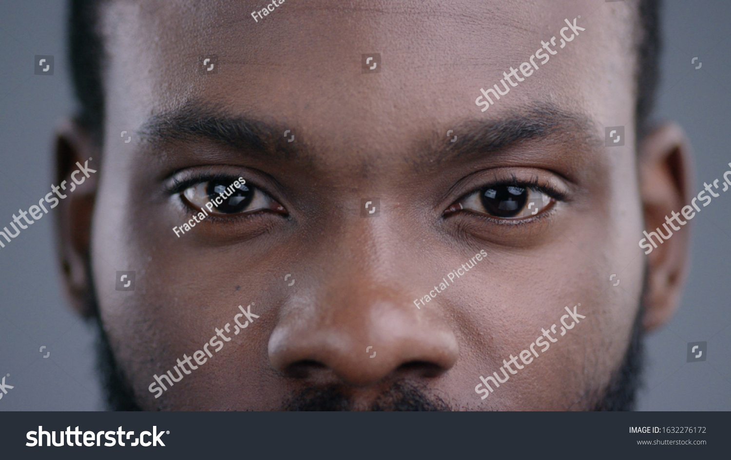 Close-up of beautiful black man eyes staring at camera. Portrait detail of serious confident african american man. #1632276172