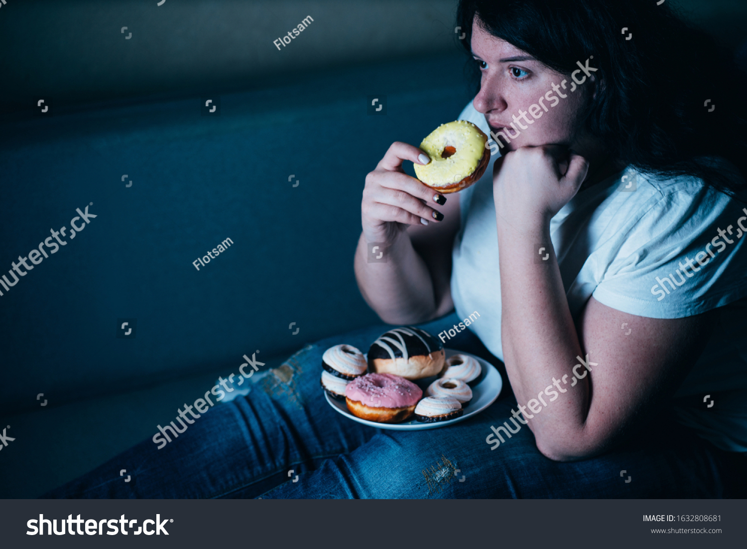 Sugar addiction, unhealthy lifestyle, weight gain, dietary, healthcare and medical concept. Cropped portrait of overweight depressed woman laying on sofa eating sugary food watching TV #1632808681