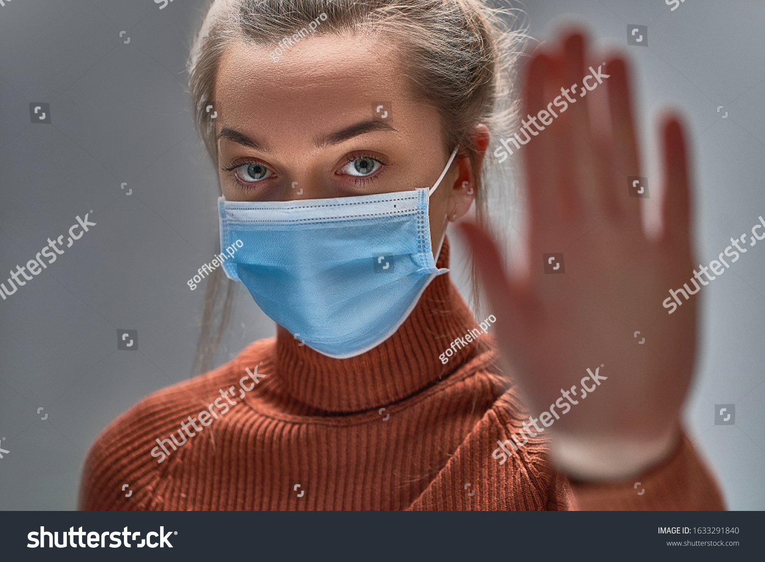 Stop the virus and epidemic diseases. Healthy woman in blue medical protective mask showing gesture stop. Health protection and prevention during flu and infectious outbreak #1633291840