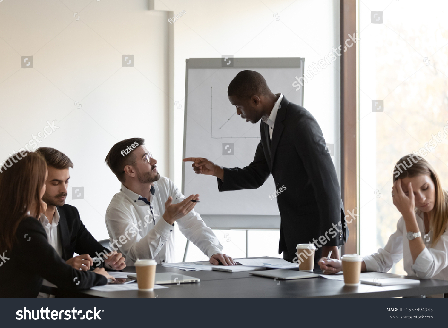 Multi-ethnic business partners having conflict accuse each other at group meeting in boardroom unpleasant situation caused by personal dislike, racial discrimination, struggle for leadership concept #1633494943