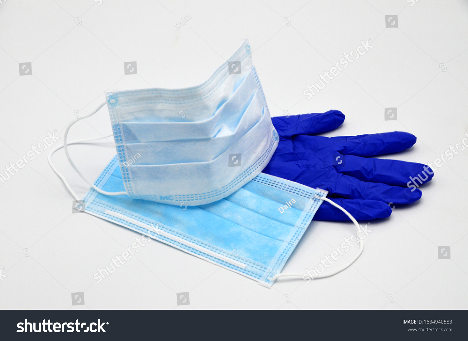 Protective face mask for protection against germs in the mouth and nose. Blue protective glove under the masks. Protection for corona virus #1634940583