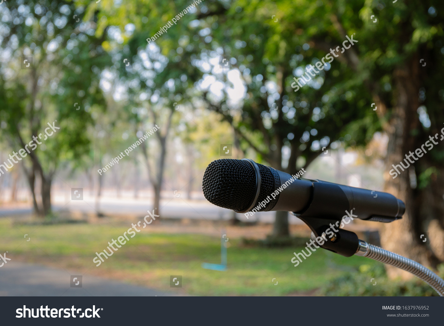 Outdoor microphone.One black microphone.A black microphone on the lawn and the road #1637976952