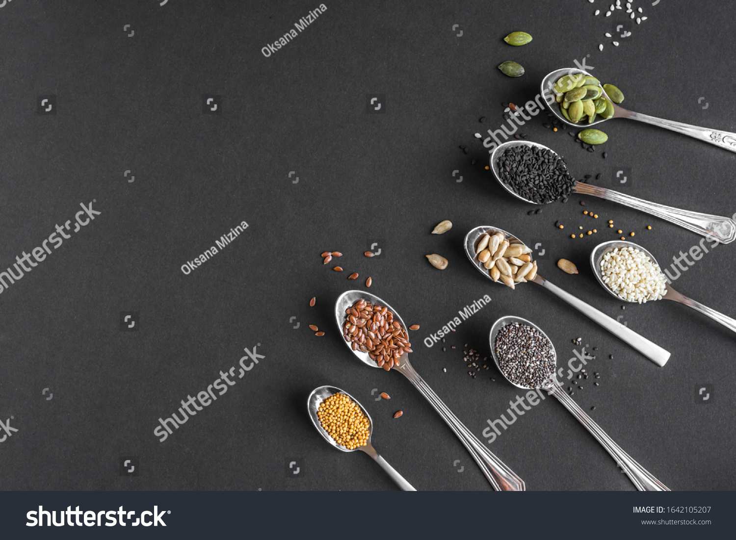 Various Seeds Assortment on black background. Set of  sesame seeds, flax seed, sunflower seeds, pumpkin seed, chia, hemp seeds in spoons, healthy food ingredients, top view, copy space. #1642105207