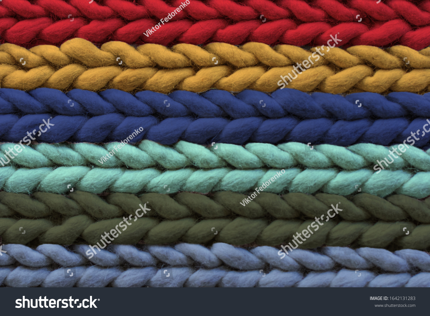 Texture of warm multi-colored woolen rug, background. Pigtail pattern, soft focus. #1642131283