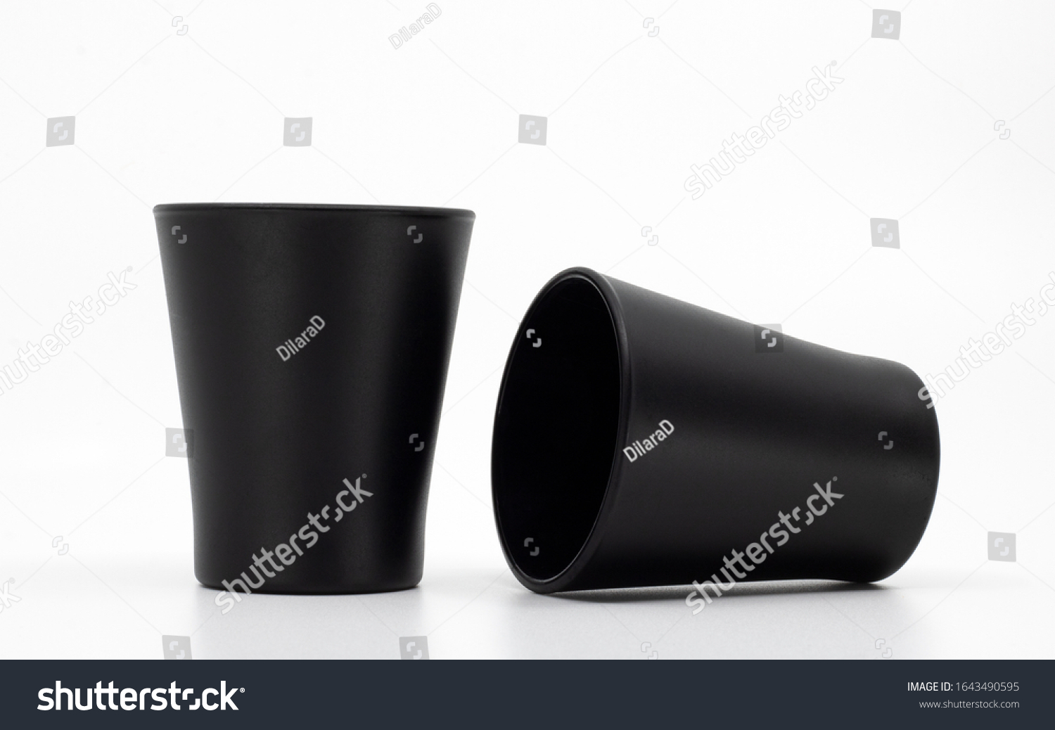 Blank mockup cups isolated on white. Two black shot glasses. Matte glass kitchenware. Empty cups or containers. #1643490595