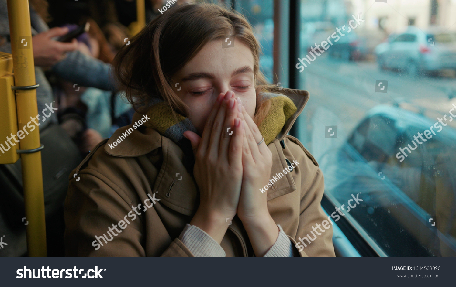 Sick young woman coughs sneezes on the tram cold autumn day flu season disease fever grippe health illness infection influenza migraine sickness slow motion #1644508090