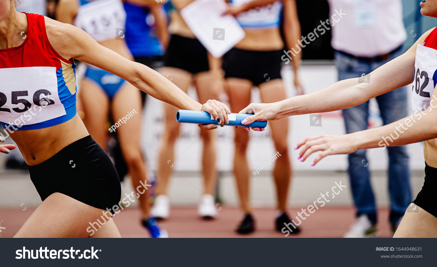 women relay team passing of baton running 4x400 meters  #1644948631